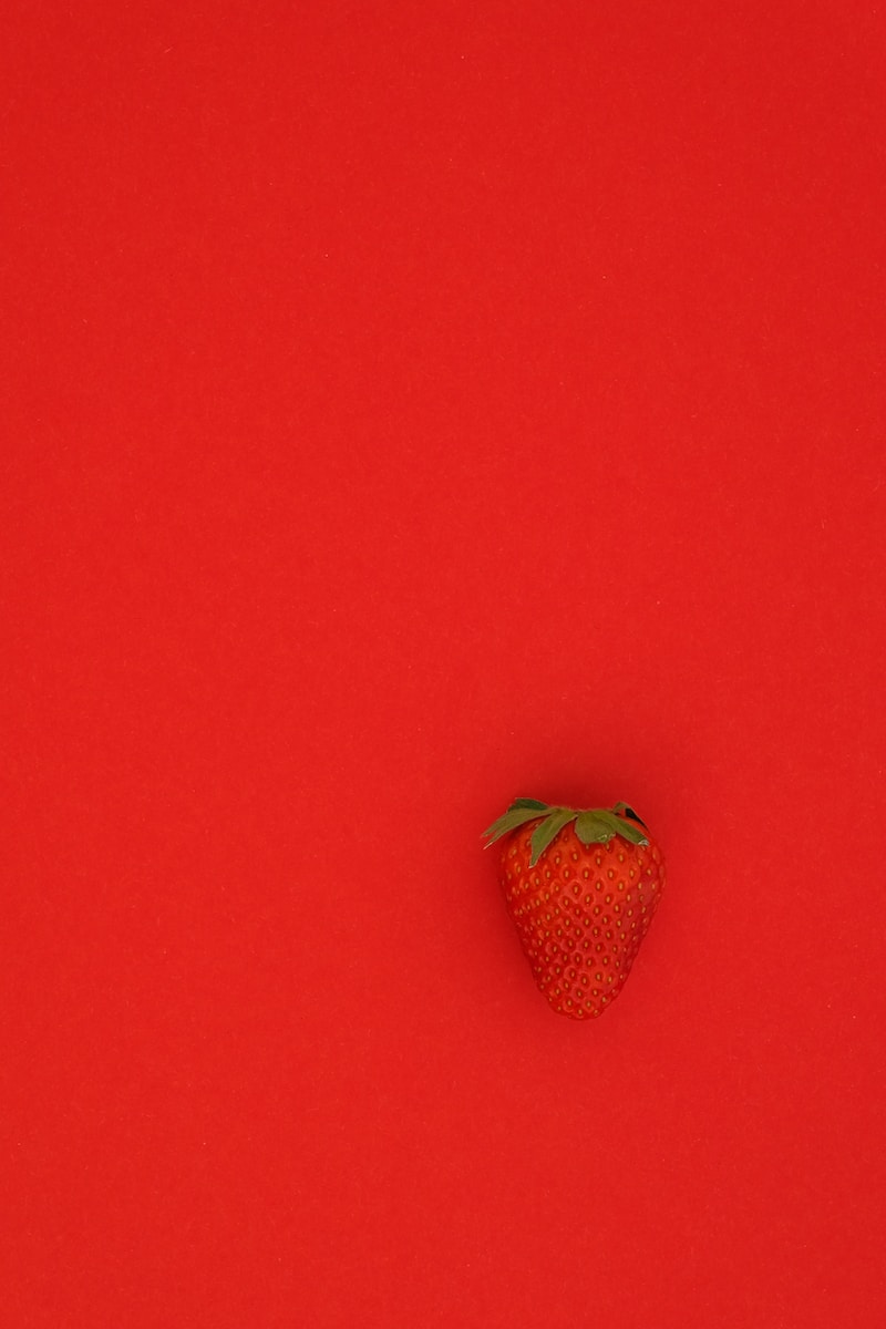 red strawberry fruit on red surface